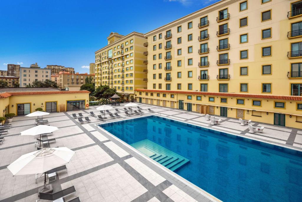 a pool with chairs and umbrellas next to a building at Hyatt Regency Baku in Baku