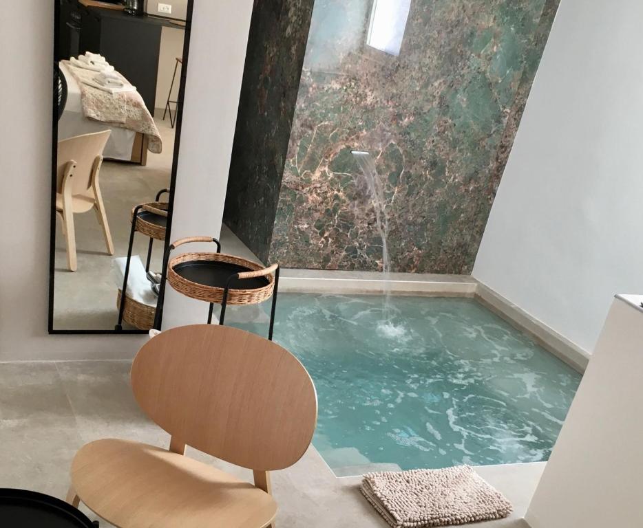 uma piscina com uma cadeira num quarto em QUIRICO GUEST HOUSE em Locorotondo