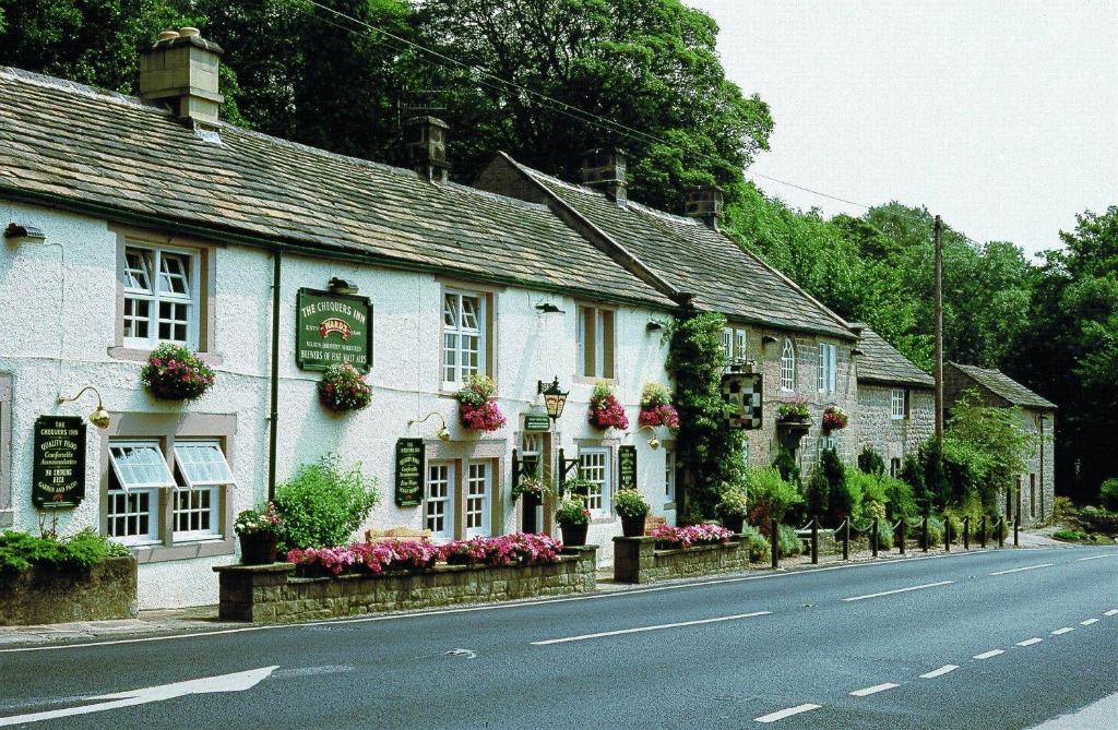 a row of white houses on the side of a street at The Chequers Inn in Froggatt