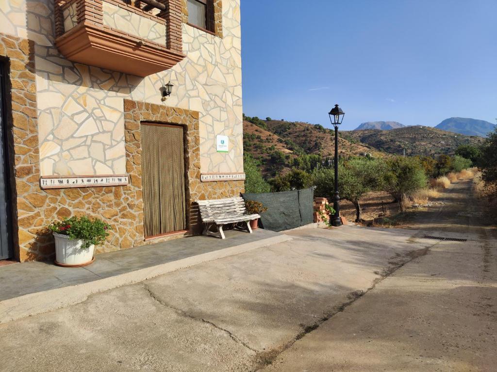 托洛斯的住宿－Casa Rural Sierra De Las Nieves，坐在大楼外的长凳,有门