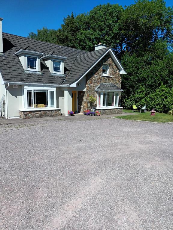 a house with a gravel driveway in front of it at Mulberry Lodge in Blarney