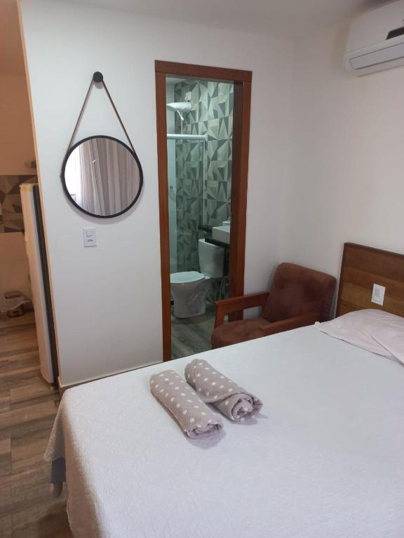 a room with a bed with a mirror and a pillow on it at FLAT Beverly Hills 401A in Vila Velha