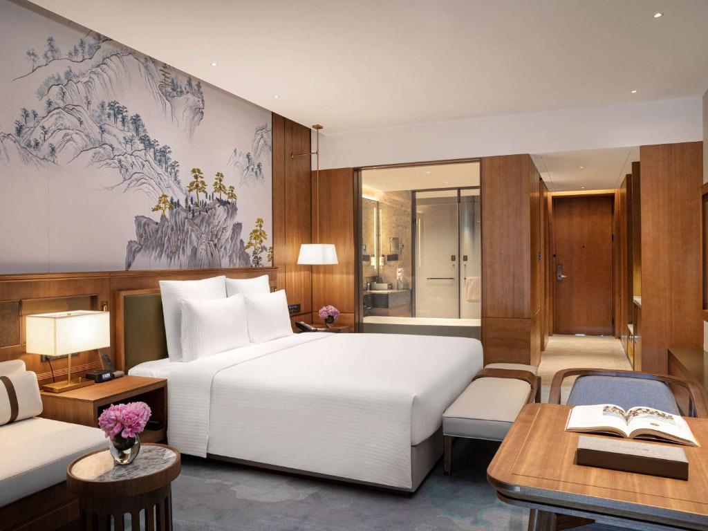 Pullman Yuxi في Yuxi: غرفة نوم مع سرير أبيض كبير ومكتب