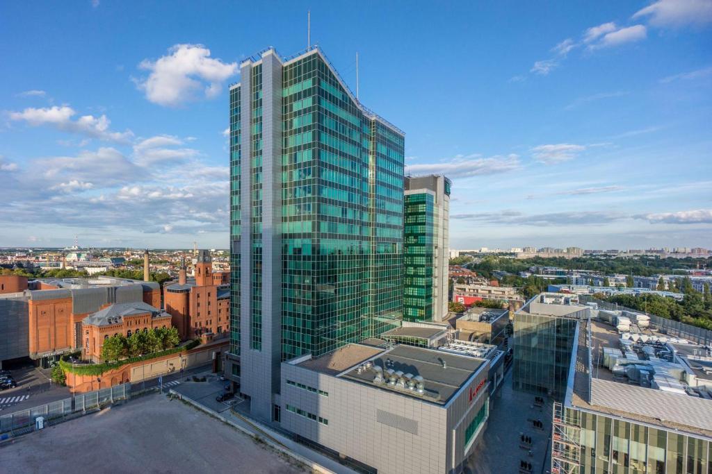 un grand bâtiment en verre dans une ville avec des bâtiments dans l'établissement Andersia Hotel & Spa Poznan, a member of Radisson Individuals, à Poznań