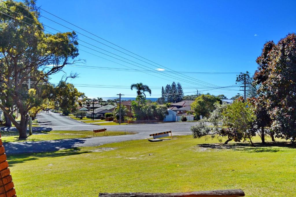 a park with benches on the grass and a street at Seaview Townhouse 3 in South West Rocks