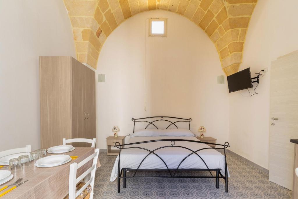 een slaapkamer met een bed en een tafel en een eetkamer bij Casa Emi by BarbarHouse in Veglie