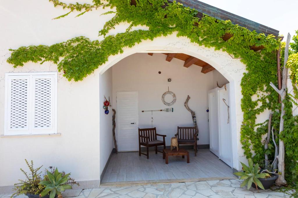 波爾托帕洛的住宿－Casale Carratois - casa vacanze - Marzameni - Noto，通往带两把椅子的庭院的拱门