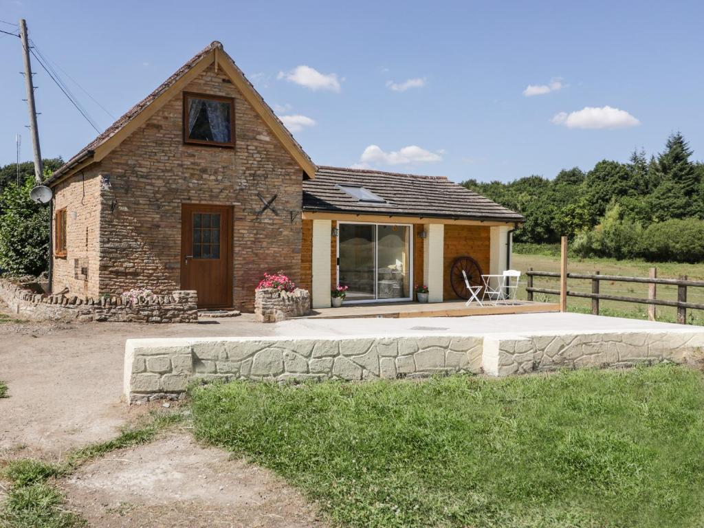 a small stone house with a patio in front of it at Steel Works Farm in Ross on Wye