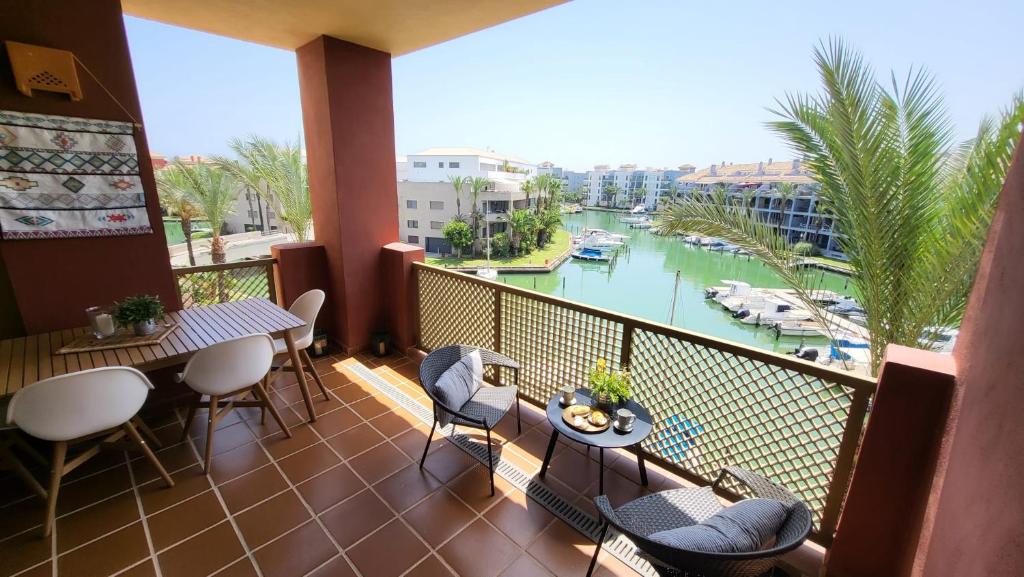 balcón con mesas y sillas y vistas al río en Marina views Sotogrande, en Sotogrande