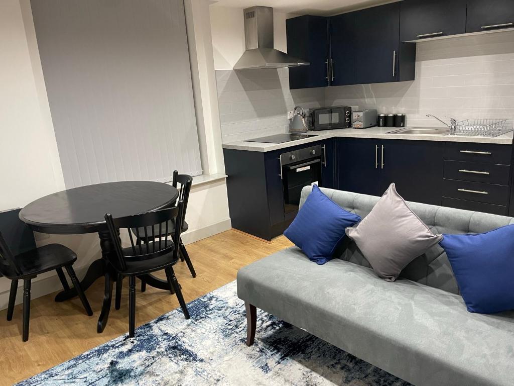 een woonkamer met een bank en een tafel met blauwe kussens bij Modern - two bed - apartment located in the city of Wolverhampton in Wolverhampton