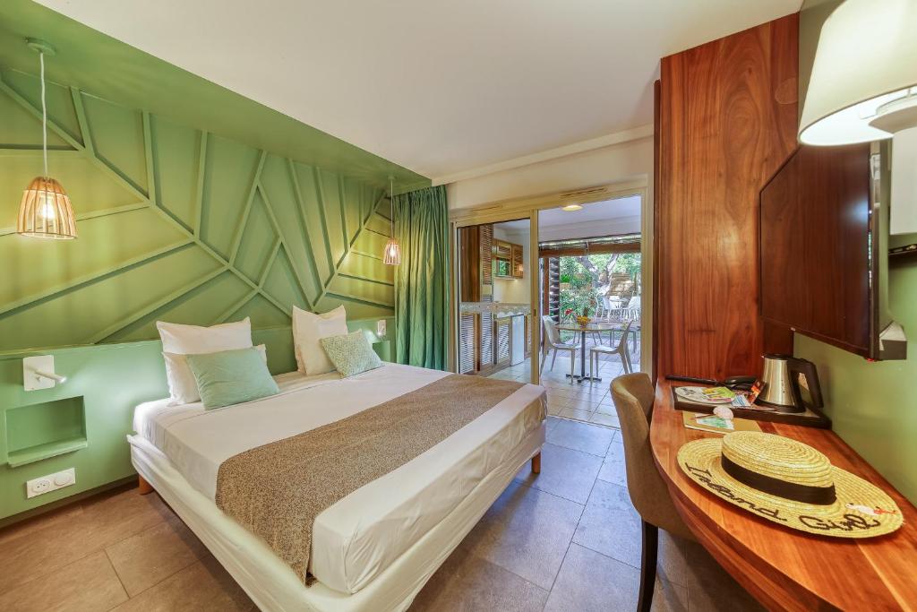 Schlafzimmer mit einem Bett, einem Schreibtisch und einem Tisch in der Unterkunft Résidence Tropic Appart Hotel in Saint-Gilles-les-Bains