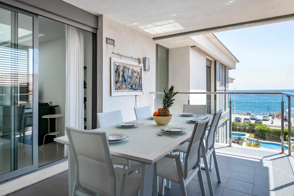 a dining room with a table and chairs and a balcony at Ático Saona in Aduanas