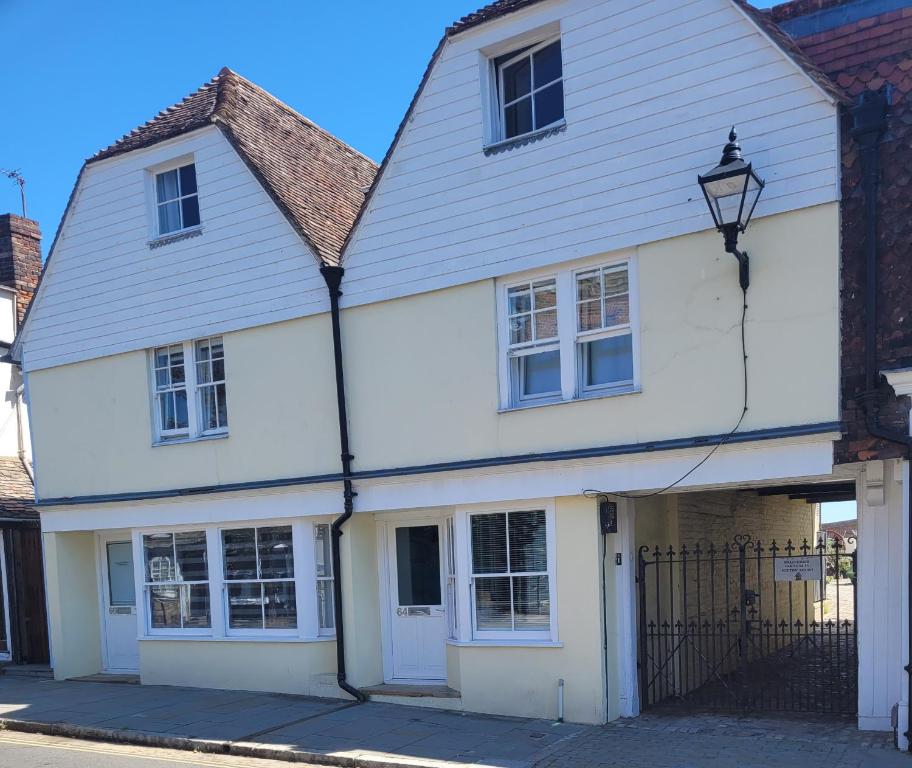 a white house with a gate in front of it at Milton House in Sittingbourne