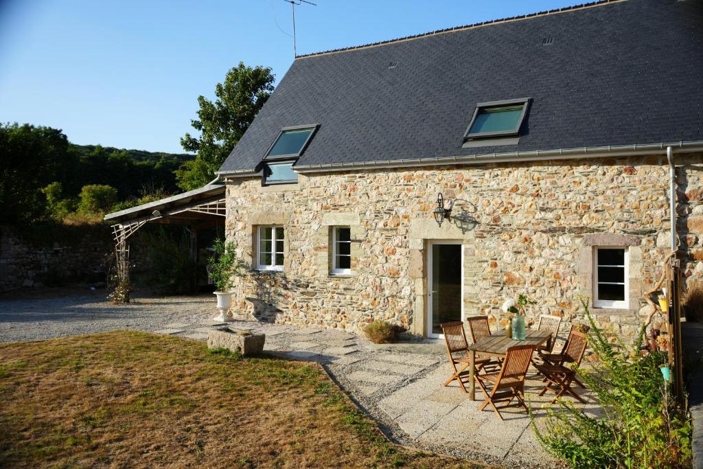 ein Steinhaus mit Stühlen und einem Tisch davor in der Unterkunft Le Cocon de Noah 