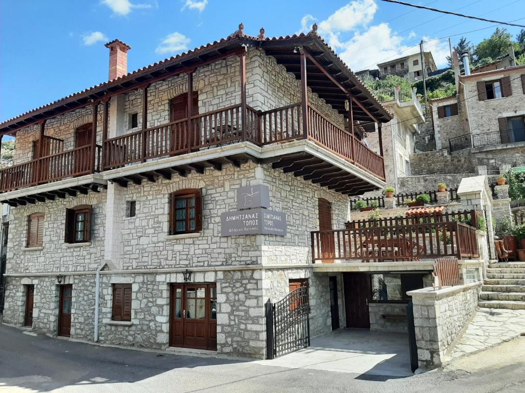 an old stone building with a balcony on top at ΔΗΜΗΤΣΑΝΑΣ ΤΟΠΟΣ Νύμφη Θεισόα in Dimitsana