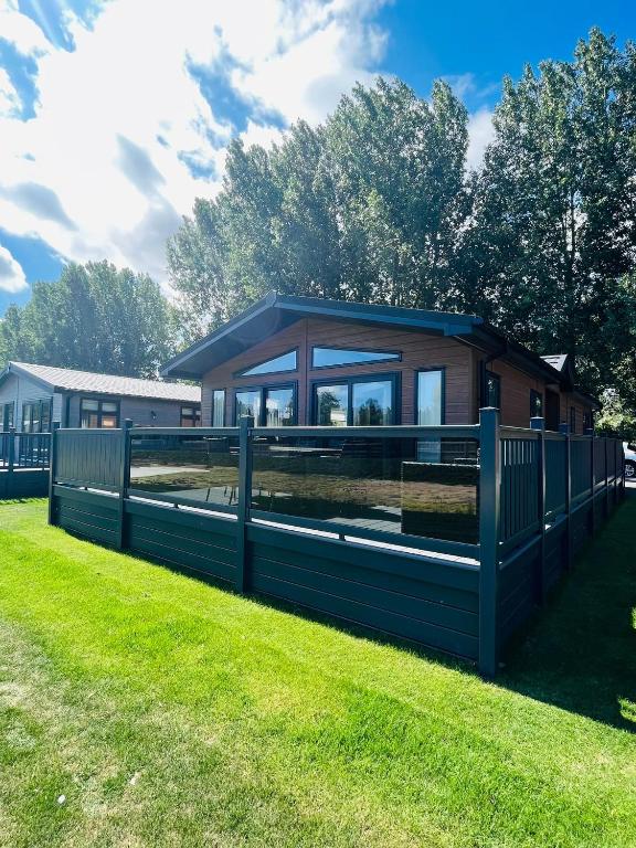 a house with a blue fence in the grass at Laburnum Lodge with Hot Tub in York