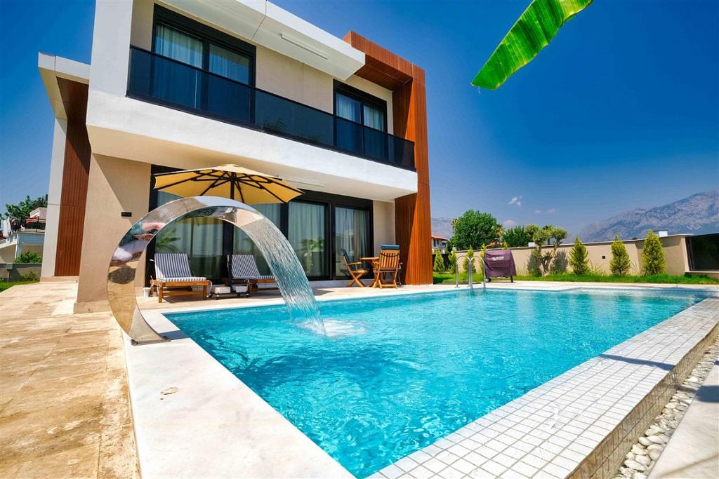 a swimming pool in front of a house at Yedisu Villaları Family Only in Kemer