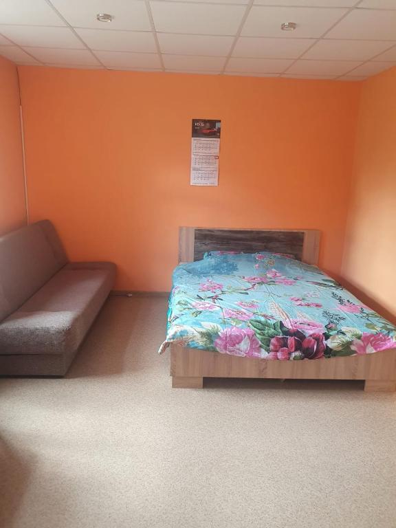 a bedroom with a bed and a couch in a room at Ukstiņa ielas apartamenti in Liepāja