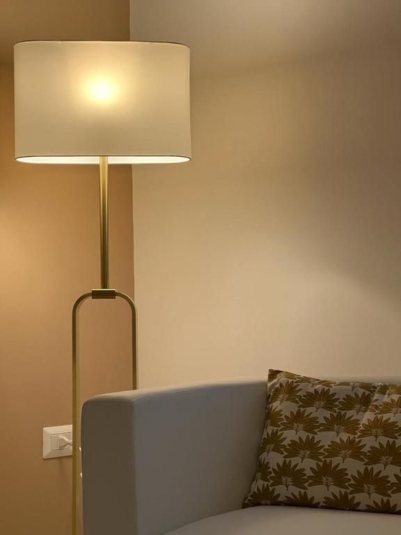 lampa siedząca obok kanapy z poduszką w obiekcie TIZIANA'S HOUSE w mieście Salerno