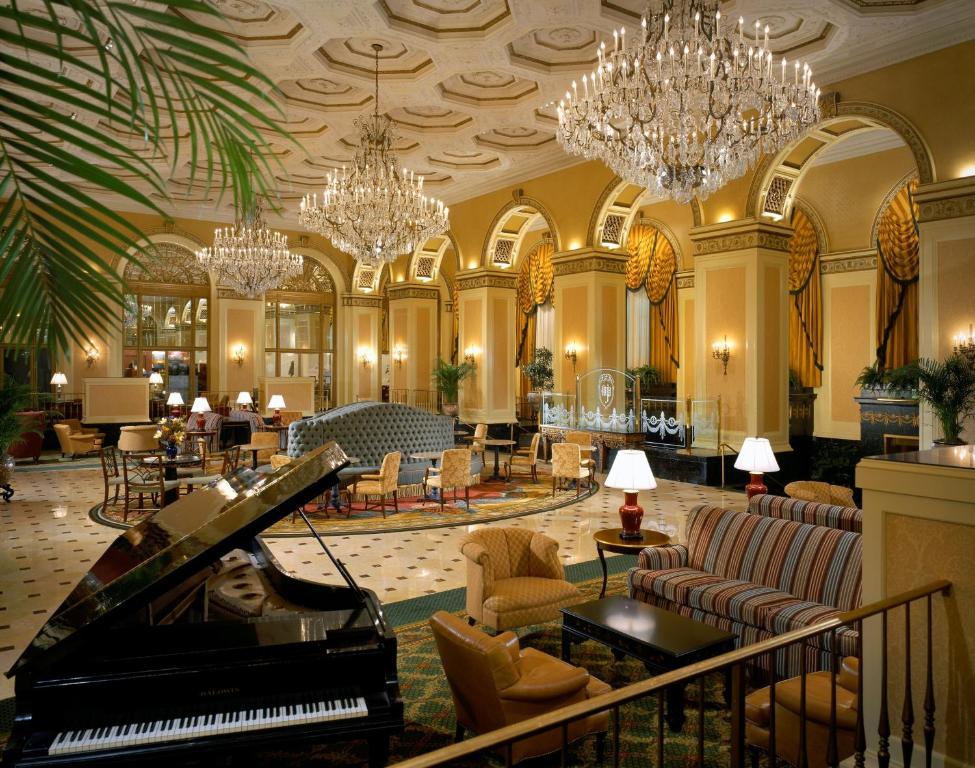 a lobby with a grand piano and chandeliers at Omni William Penn Hotel in Pittsburgh