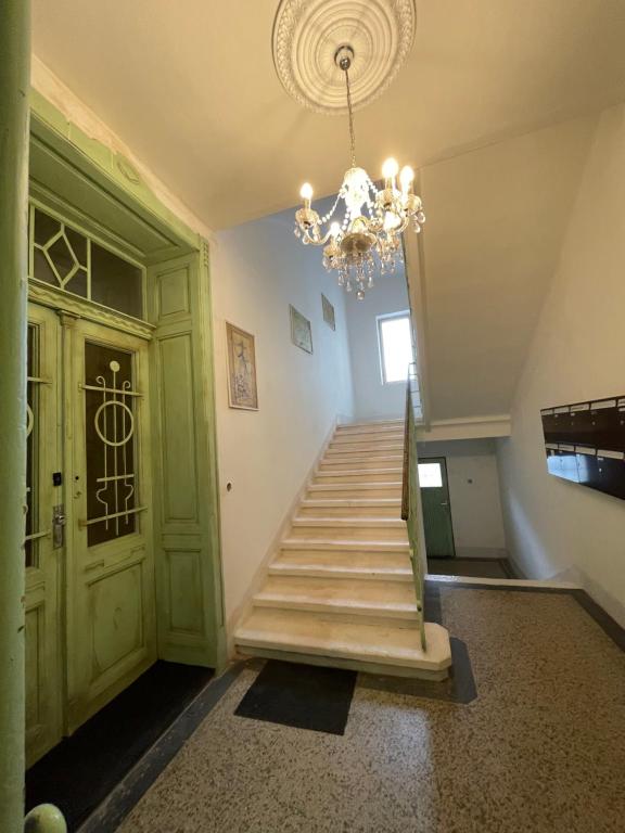 a hallway with a staircase with a chandelier at Red&Black Apartment City centr, Na Hradbách 118 in Ostrava