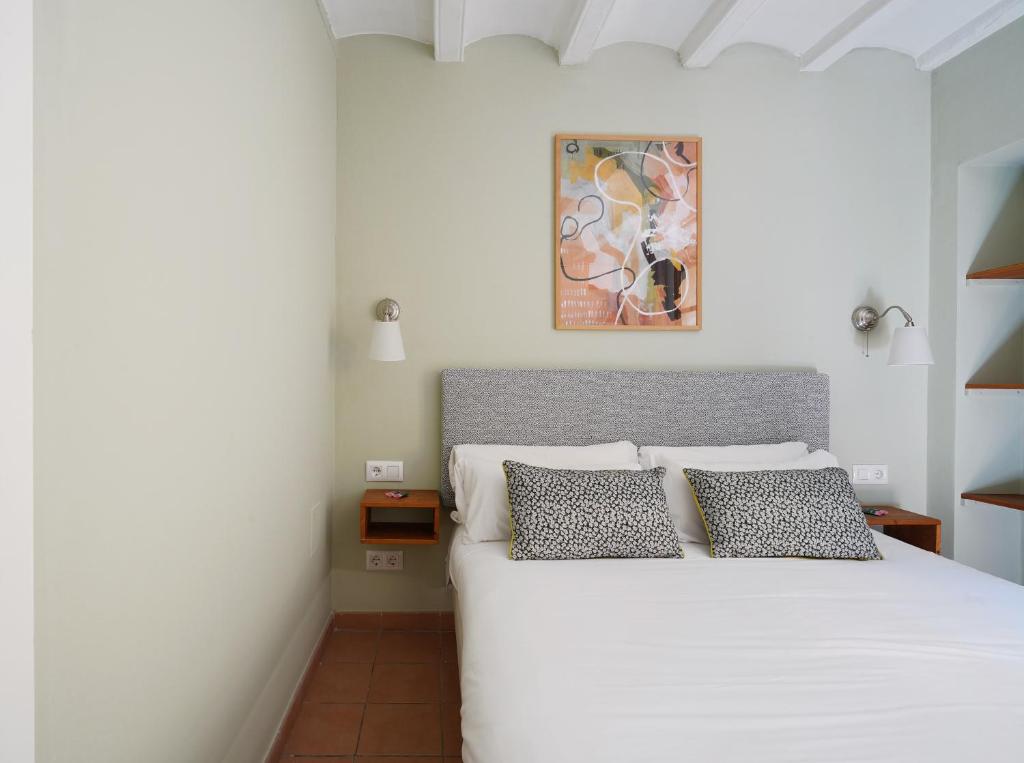 um quarto com uma cama branca e 2 almofadas em numa I Seda Apartments em Barcelona