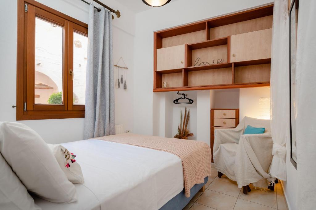ナクソス・コラにあるSmall Apartment in Grotta Naxosのベッドルーム1室(ベッド1台、椅子、窓付)