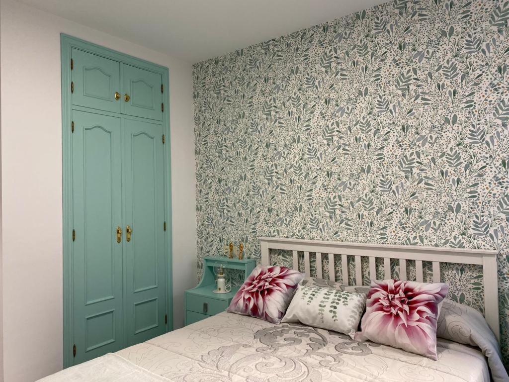 a bedroom with a bed with pink and white pillows at Aire de Sanabria Puebla in Puebla de Sanabria