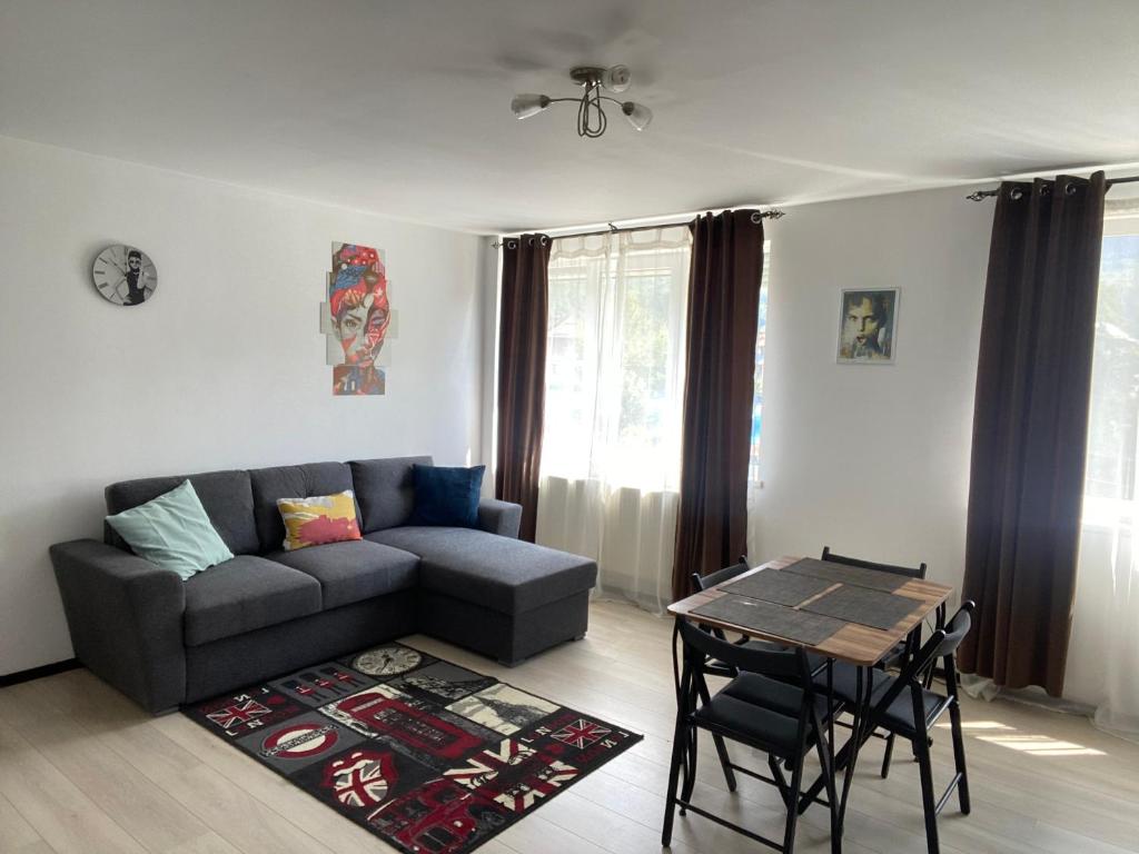 uma sala de estar com um sofá e uma mesa em Tourist Apartment 1 em Piatra Neamţ