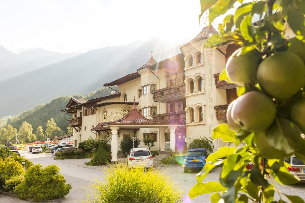 a town with cars parked in front of a building at Appartements Alpenschlössl in Neustift im Stubaital