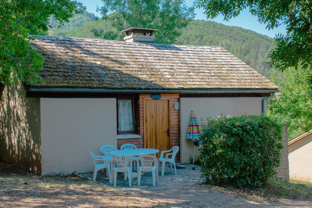 una pequeña casa con una mesa y sillas frente a ella en Village de Gîtes de La Canourgue, en La Canourgue