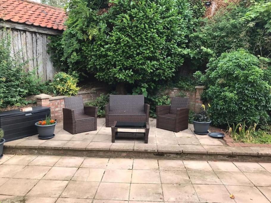 a patio with two chairs and a coffee table at 4 Bedroom townhouse on one of the oldest streets in Wymondham