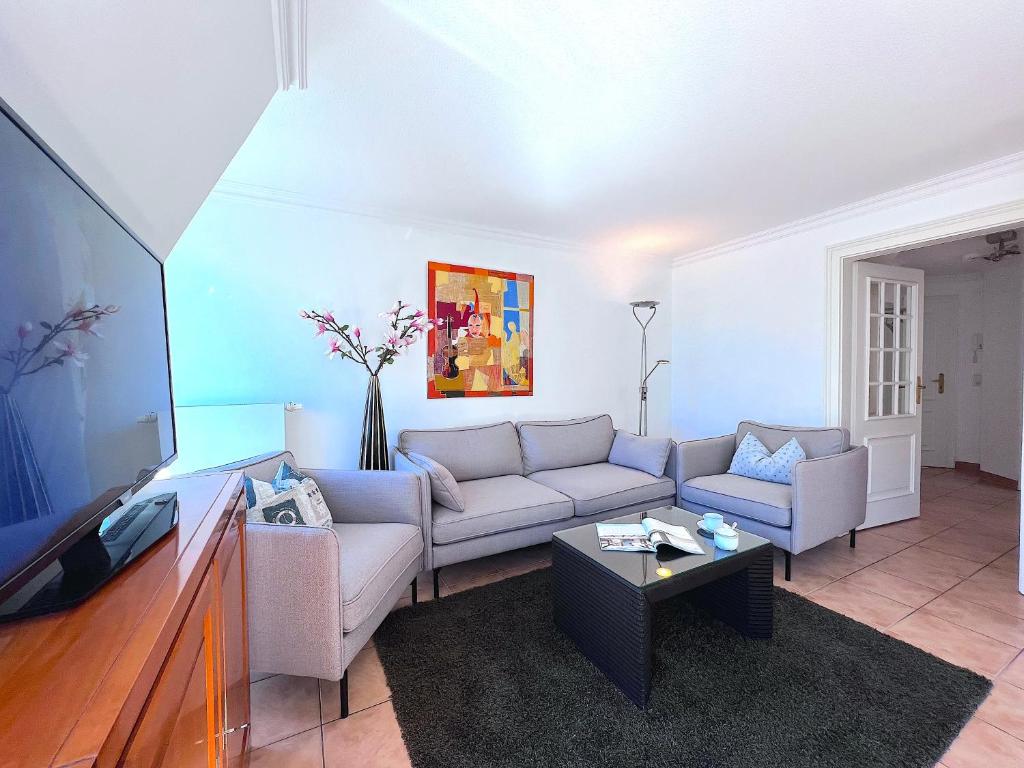 ein Wohnzimmer mit einem Sofa und einem TV in der Unterkunft Suite Boysen No.15 in Westerland