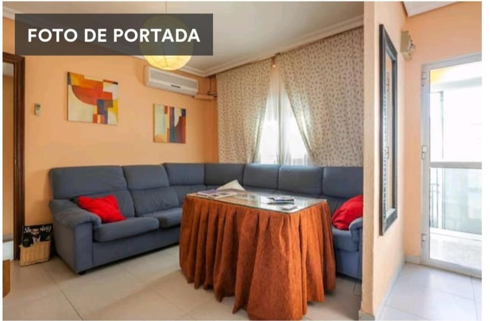 a living room with a blue couch and a table at PISO CON BUENA RED WIFFI FIBRA ÓPTICA Alquiler de habitaciones in Seville