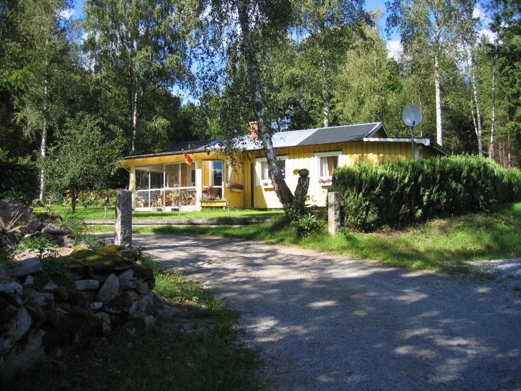 Svängsta的住宿－Almagården lantlig miljö，前面有一条碎石路的黄色房子