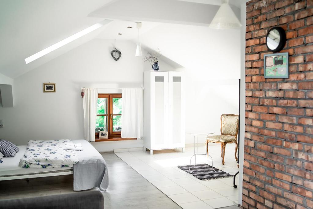 a bedroom with a bed and a brick wall at Apartamenty Stacja Kasina in Kasina Wielka