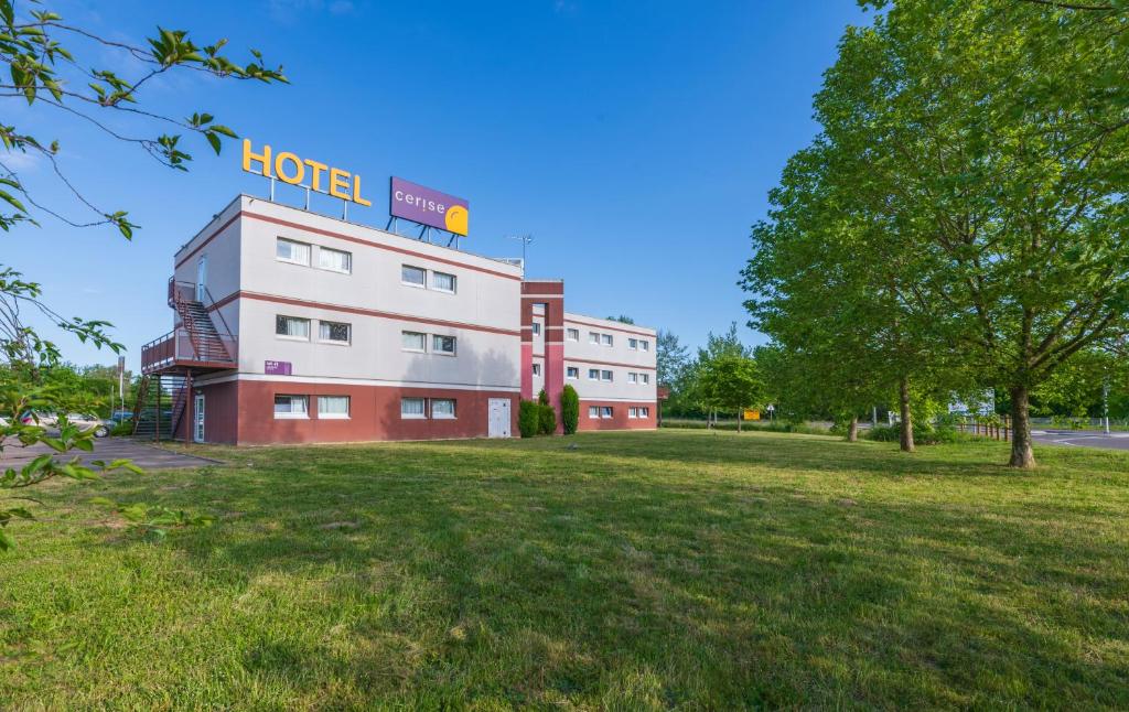 ein Gebäude mit einem Hotelschild darüber in der Unterkunft Hôtel Cerise Auxerre in Monéteau