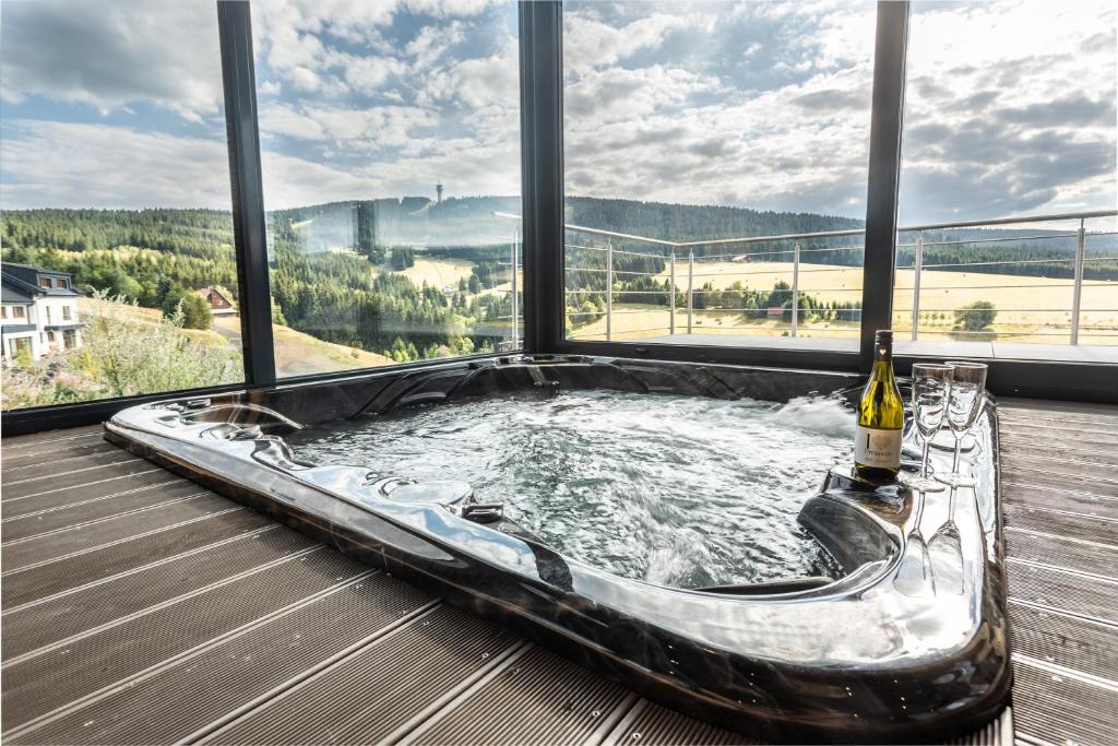 bañera de hidromasaje en una terraza con vistas en Wellness Villa Klínovec Views, en Loucná pod Klínovcem