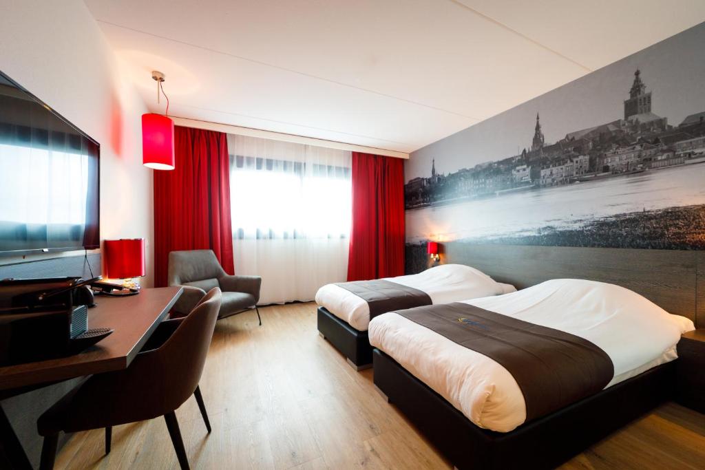 a hotel room with two beds and a desk at Bastion Hotel Nijmegen in Nijmegen