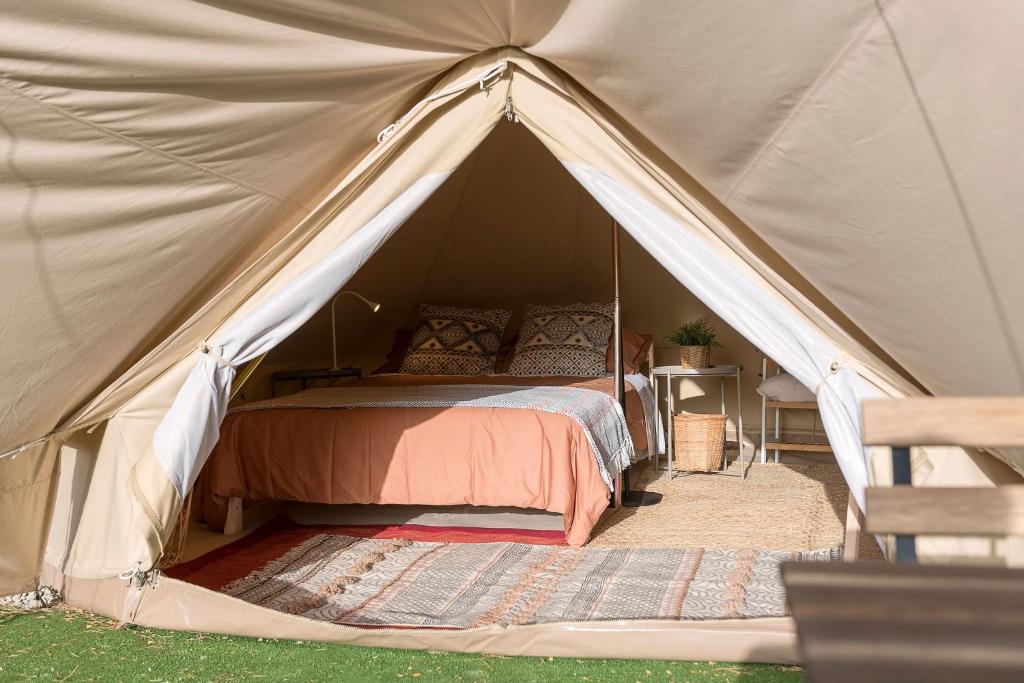 a bedroom with a bed in a tent at Glamping La Mimosa CONIL in Conil de la Frontera