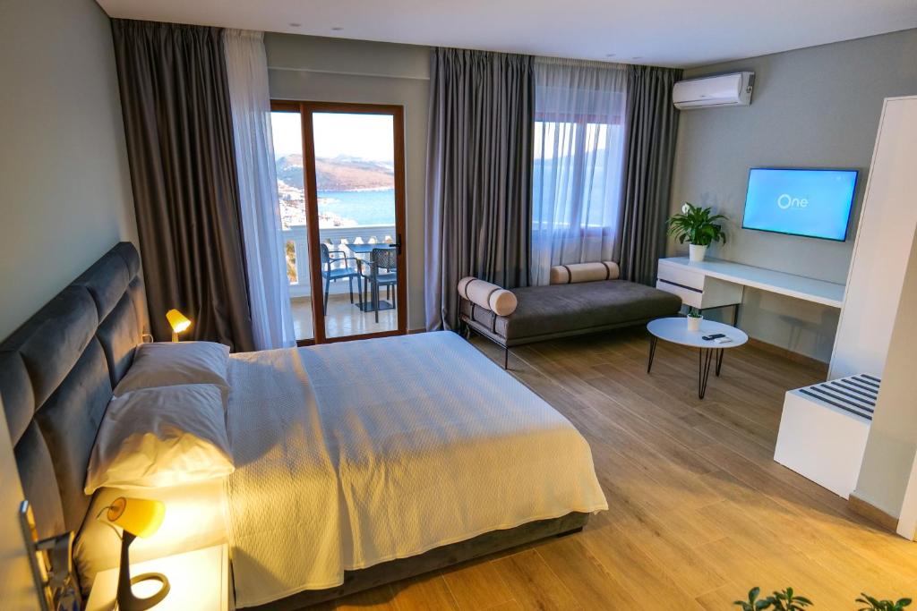 una camera d'albergo con un grande letto e un soggiorno di Sky Way SKK Luxury Apartments a Sarandë