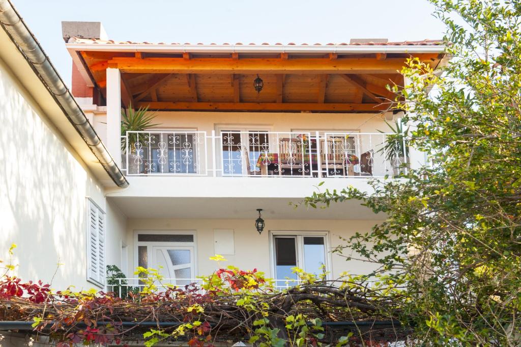 a white house with a balcony with flowers at House Glasnović in Cavtat