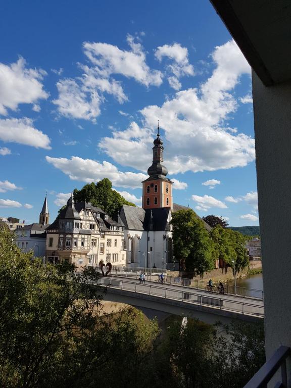 un ponte di fronte a un grande edificio con torre di 4L Riverside - Naheblick im Herzen der Bad Kreuznacher Altstadt a Bad Kreuznach