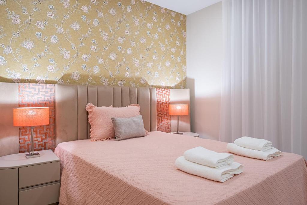 um quarto com uma cama rosa com duas toalhas em Urban Paradise by Madeira Sun Travel no Funchal