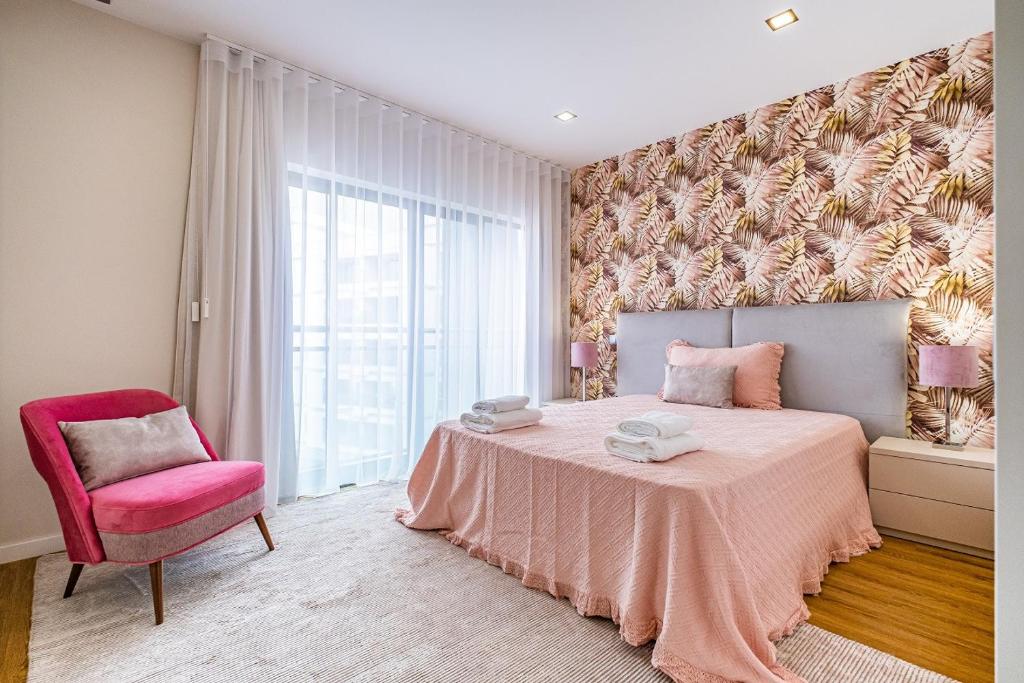 フンシャルにあるUrban Paradise by Madeira Sun Travelのベッドルーム1室(ピンクベッド1台、ピンクの椅子付)