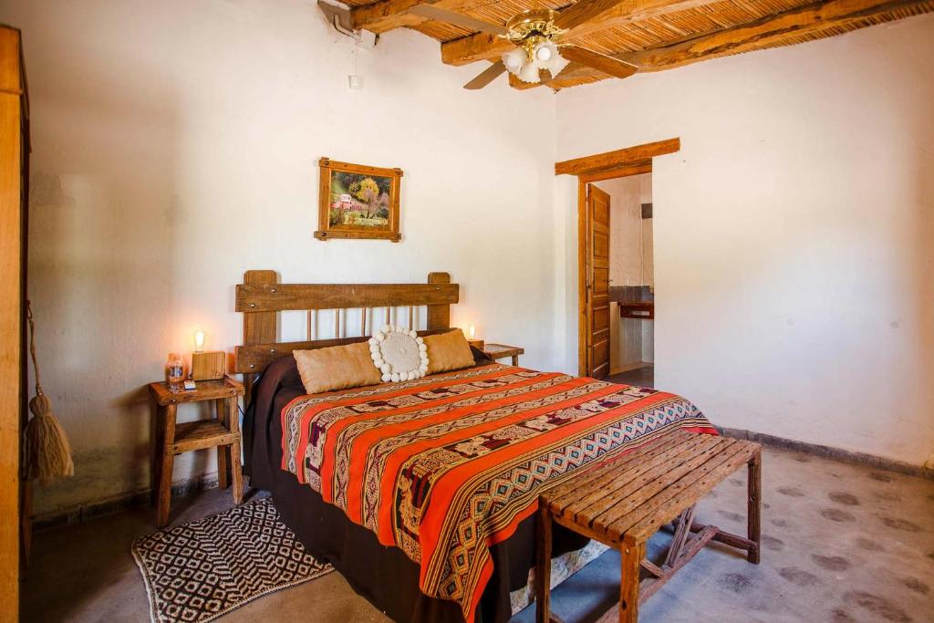 a bedroom with a bed and a table and a ceiling at Estancia Rio de Arena 