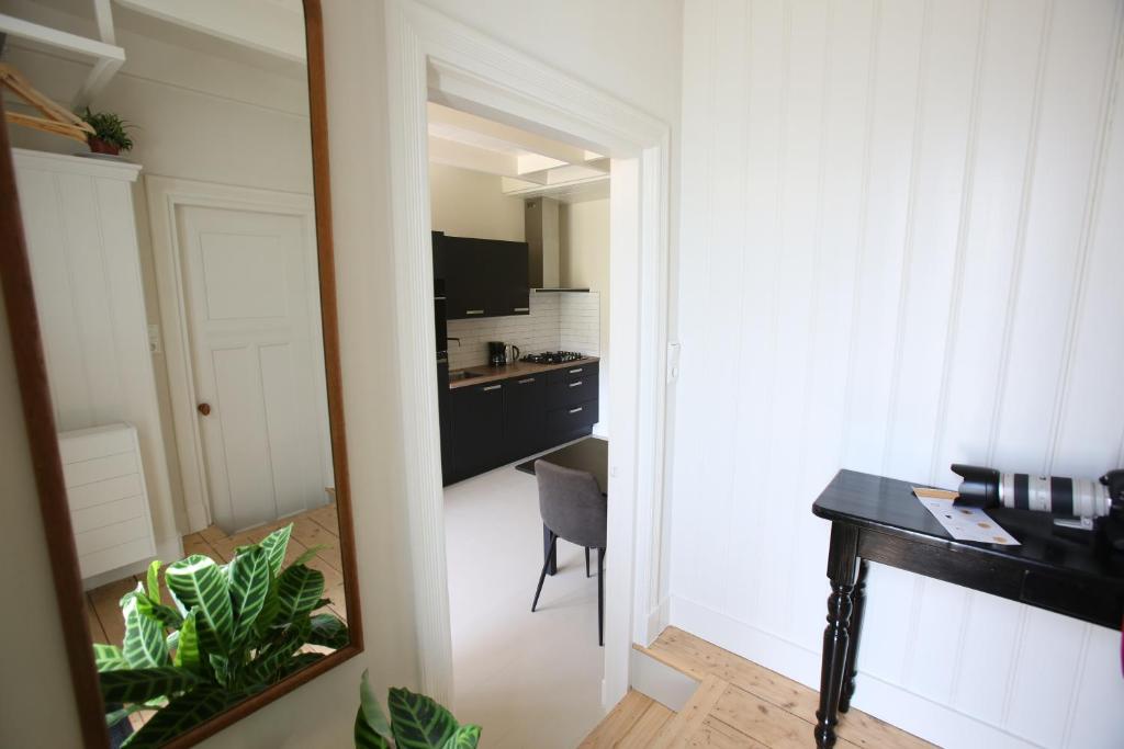 a mirror in a room with a desk and a kitchen at Recreatieappartement BoerdeRijlst - De Kamer in Sint Nicolaasga