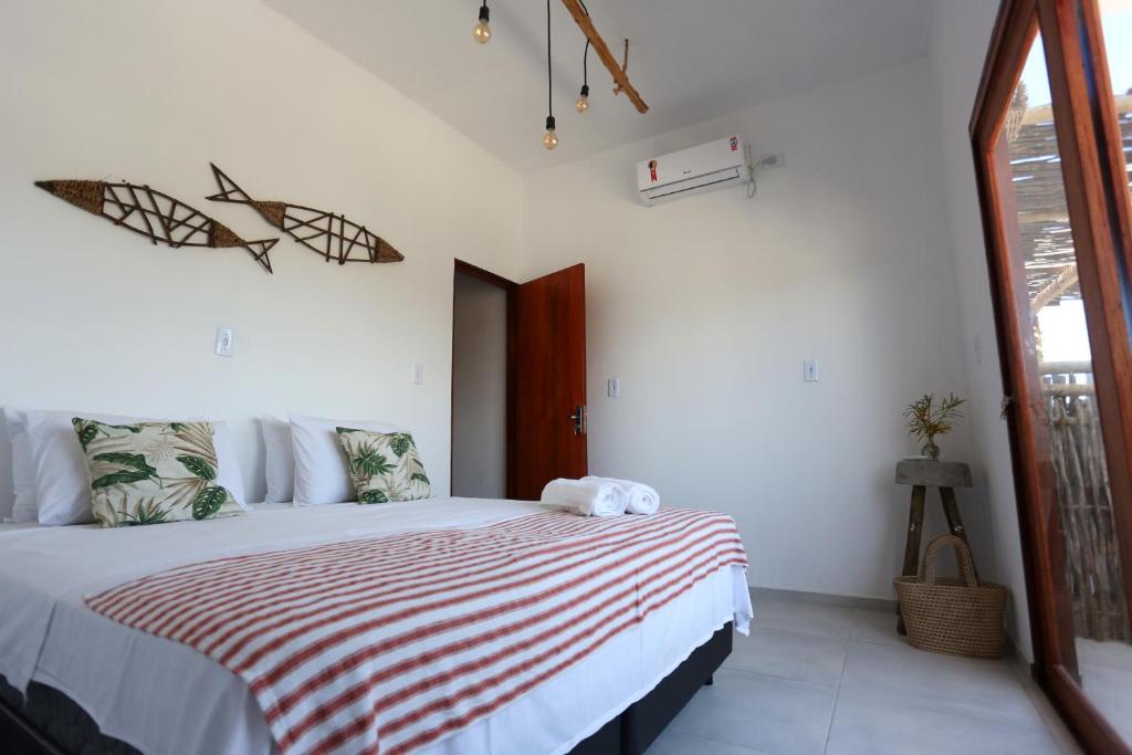 a bedroom with a bed with a red and white striped blanket at Pousada Movimento in Prea