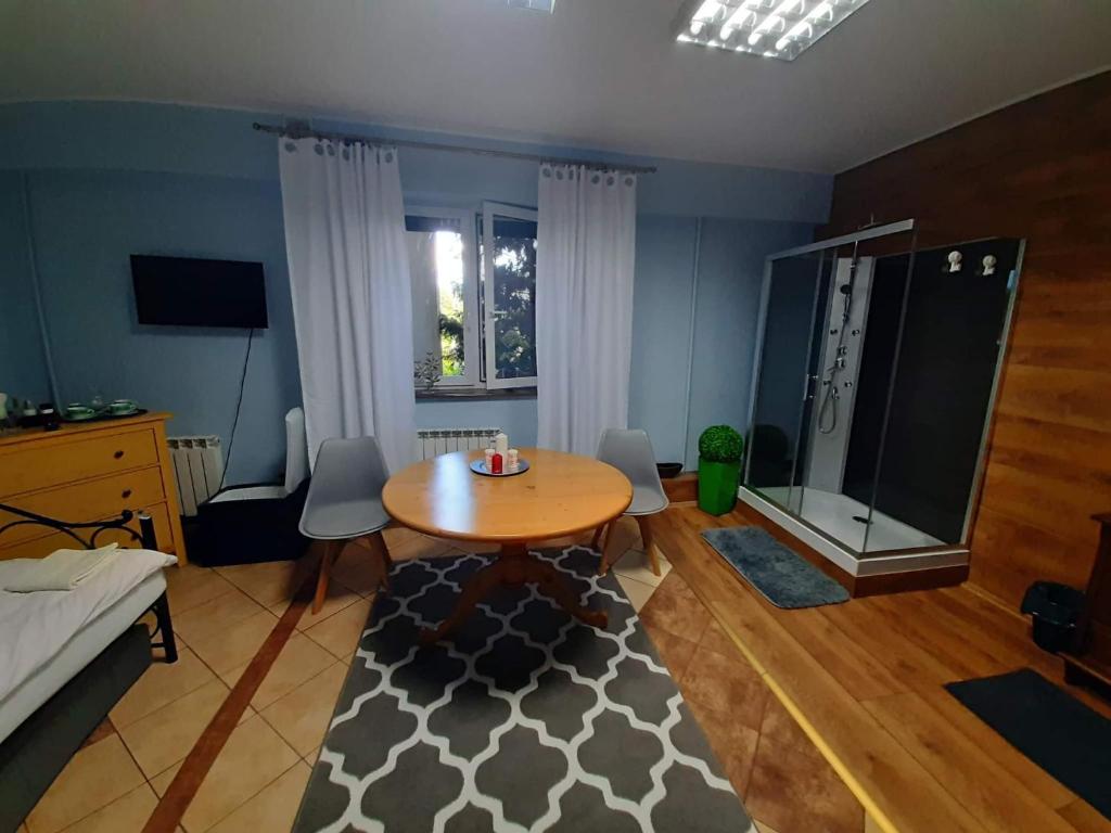 een woonkamer met een houten tafel en een tafel en stoelen bij Cottage Room- Agroturystyka in Strzegowo-Osada