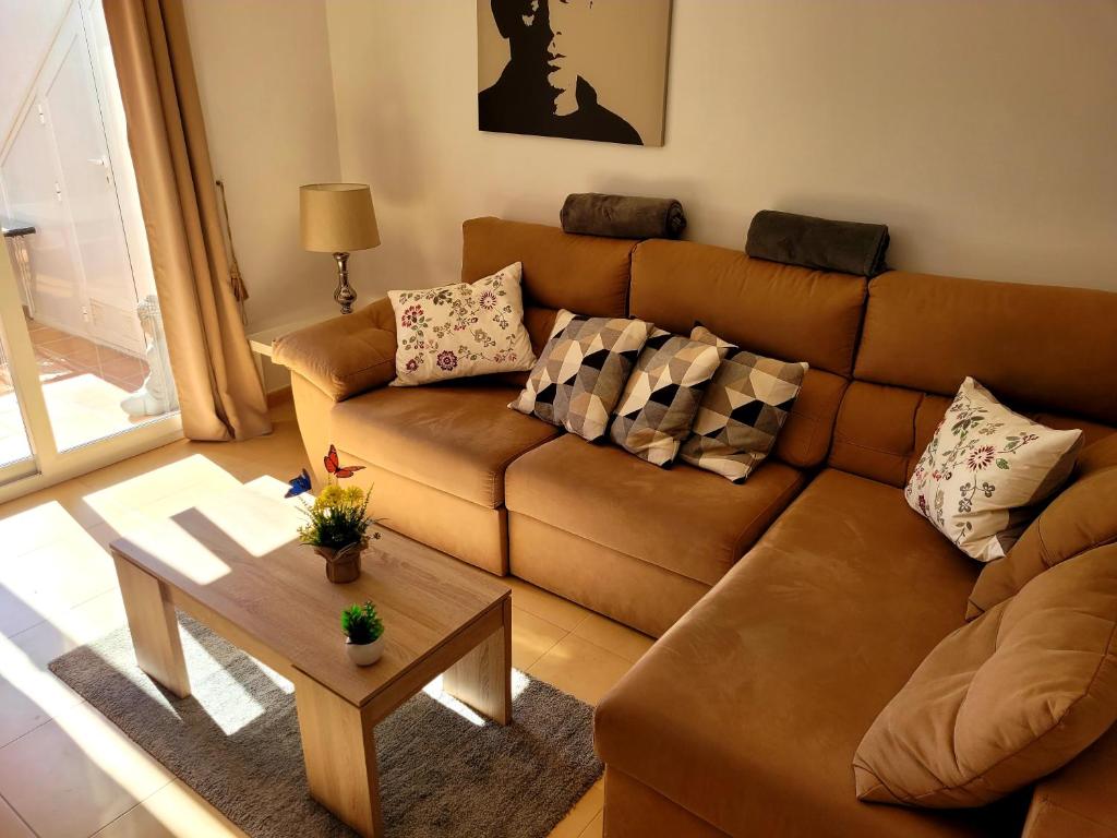 a living room with a brown couch and a table at JARDIN 8 JOZMAR in Alhama de Murcia